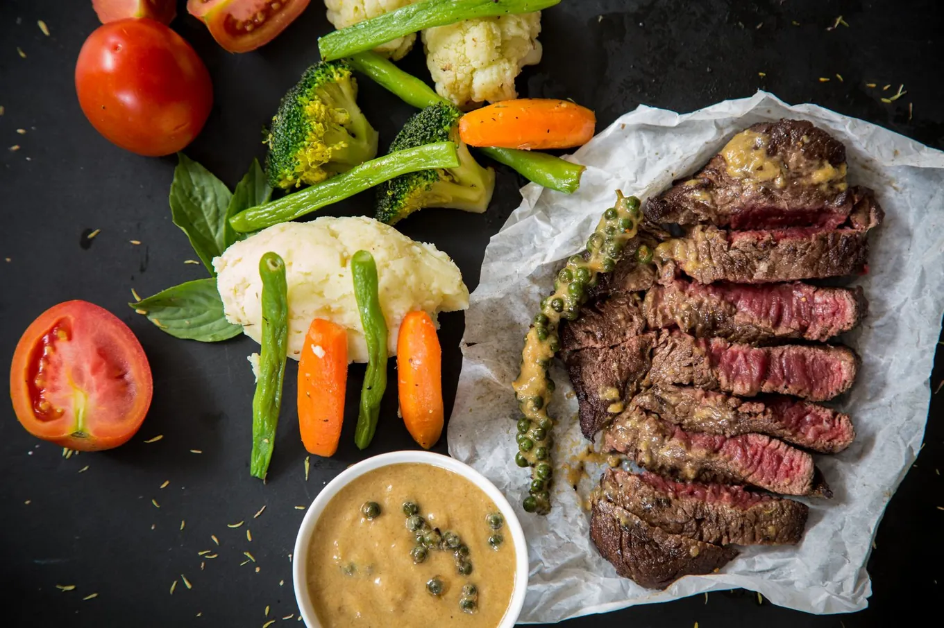 Food first: a little red meat and iron-rich plants, paired with vitamin C Plate of sliced red steak with green vegetables, carrots, and tomatoes