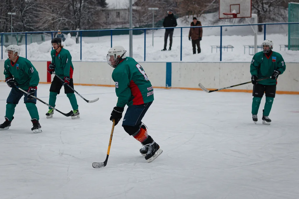 Team and racket sports build speed, agility, coordination and reaction time, none of which the bike develops Amateur ice hockey players in green jerseys skating with the puck on a snowy outdoor rink
