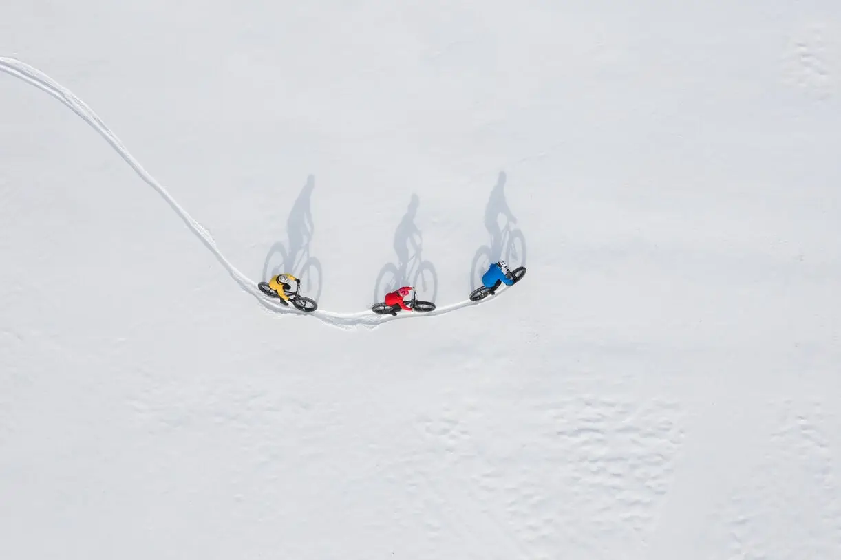 Three cyclists in snow