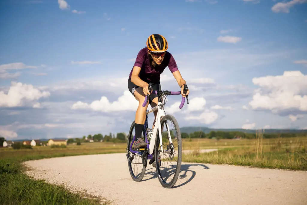Saturday: long ride, group ride or trail day Cyclist riding a gravel road through open farmland under a summer sky