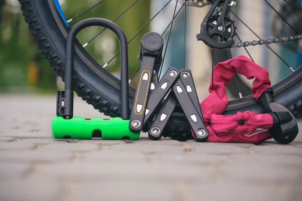 U-lock, folding lock and chain lock U-lock, folding lock and chain lock lined up beside a bicycle wheel