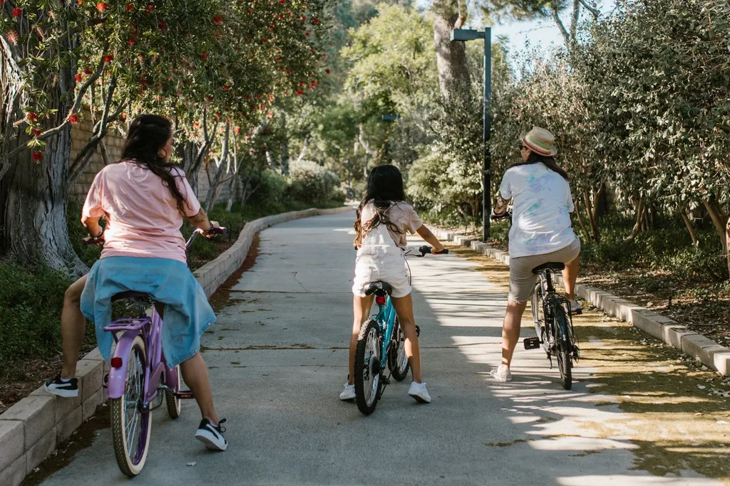 Family ride on a shared-use path Family riding bikes together on a tree-lined shared-use path