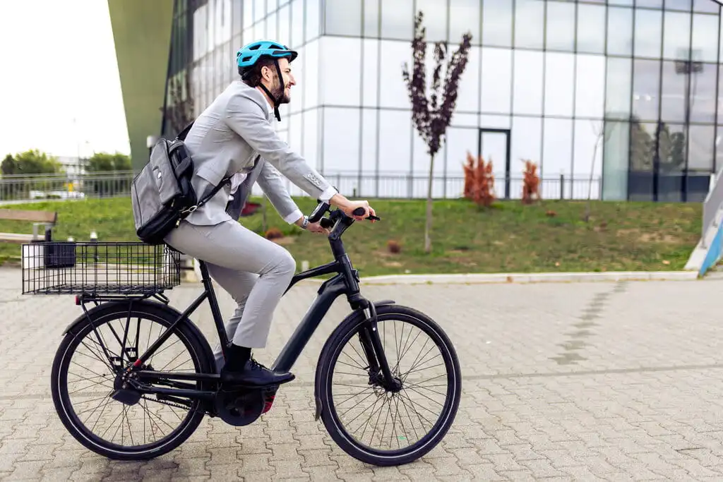 A commuter riding an e-bike through a city plaza