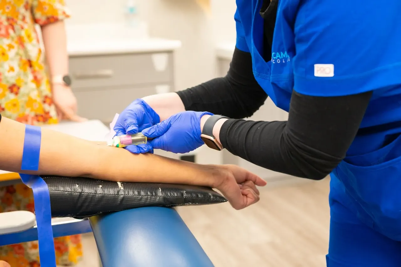 Bloodwork rules out the conditions that mimic overtraining before anyone settles on the diagnosis Nurse in blue scrubs drawing blood from a patient's arm