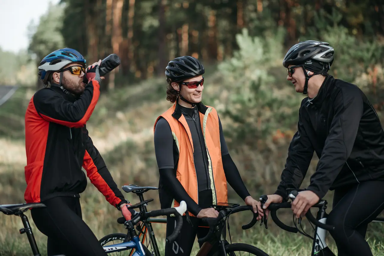 Underfueling gets you to the same place as overtraining, only faster Three road cyclists stopped at the roadside, one drinking from a bottle