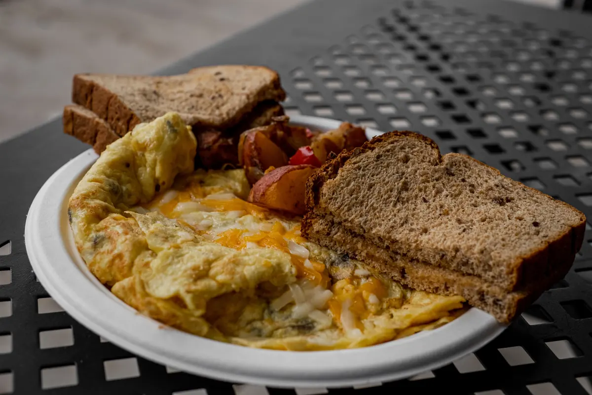 Plate of scrambled eggs with roasted potatoes and whole-grain toast, a 30 to 40 gram protein meal
