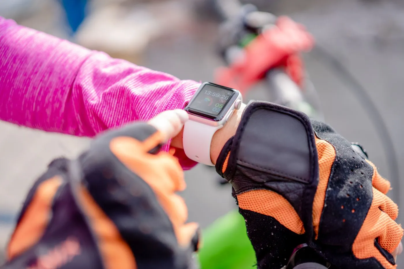 Cyclist checking heart rate and activity data on a smartwatch during a ride