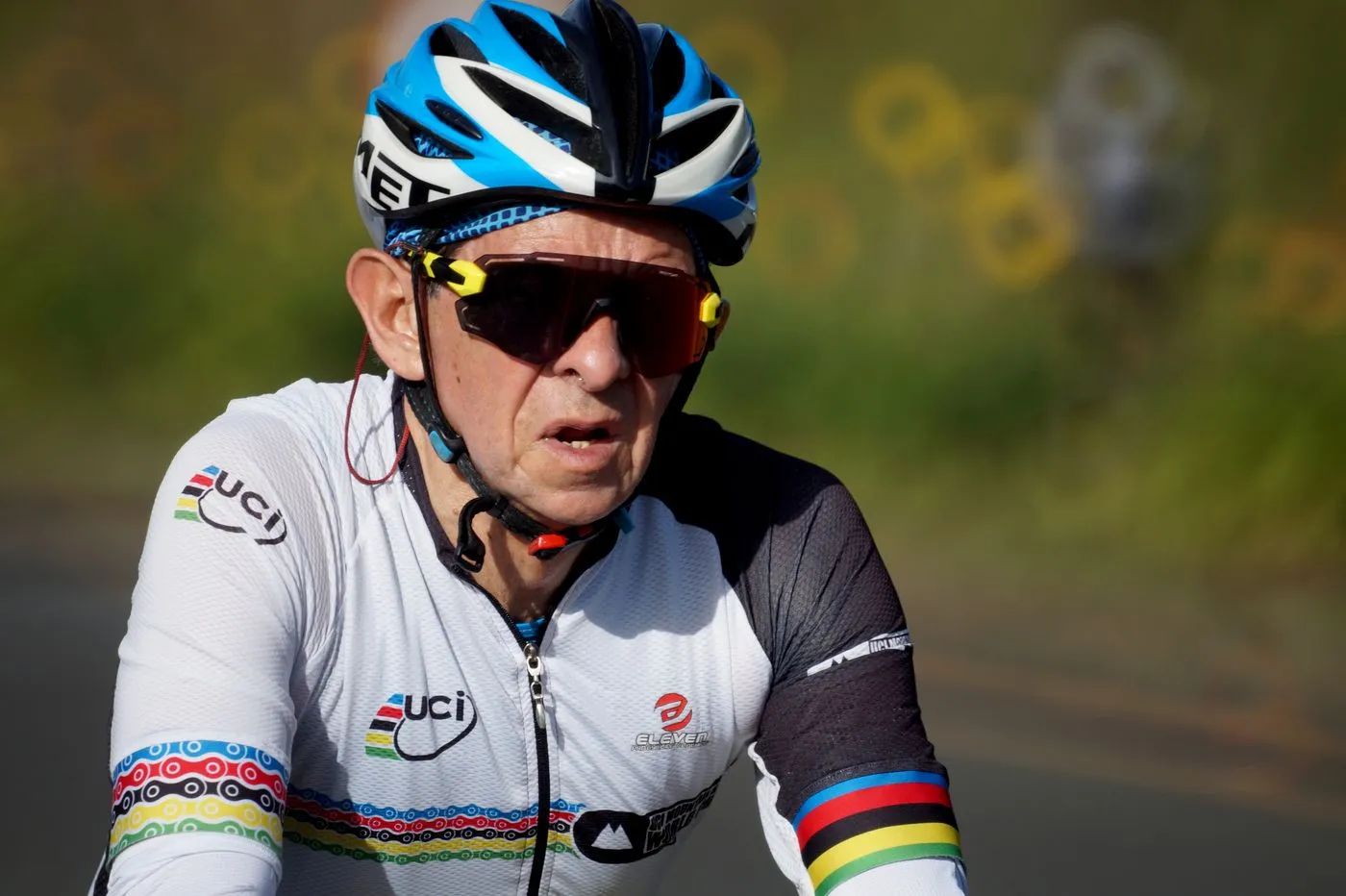 Older masters cyclist riding at a focused, steady effort on the road